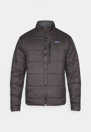 Juoda pūkinė striukė su užtrauktuku priekyje, siūta tekstūra ir stovinčiu apykakliu. Kairėje krūtinės pusėje yra logotipas, šonuose užtrauktuku užsegamos kišenės.