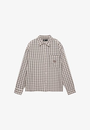 Chemise à manches longues boutonnée avec un motif écossais beige, marron et noir, col pointu et poche poitrine avec un petit motif brodé.