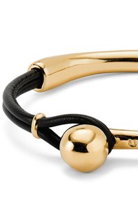 Pulsera de cordón de cuero negro con tubo de metal dorado pulido y detalle de cuenta esférica sobre fondo blanco.
