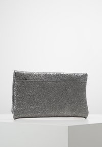 Borsa a mano metallica argentata lucida con una superficie texture, forma rettangolare piatta e chiusura superiore a battente. Design semplice ed elegante.