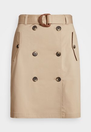 Jupe beige longueur genou avec double rangée de boutons sur le devant, poches à rabat sur les côtés, et ceinture assortie avec une boucle arrondie.