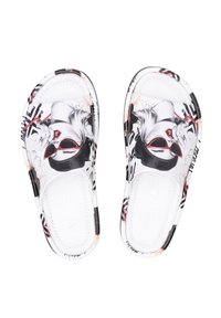 Witte instap-slippers met grafische prints van een vrouw met rode zonnebril en rode lippen, versierd met zwarte en roze bloemmotieven.
