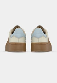 Αθλητικά παπούτσια με κρέμα επάνω μέρος, ανοιχτό μπλε και καφέ λεπτομέρειες, και παχιά καφέ σόλα, με λείο υλικό και μινιμαλιστικό σχέδιο.