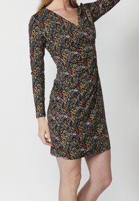 Czarna sukienka z długim rękawem, ozdobiona kwiatowym wzorem w kolorze czerwonym, żółtym i zielonym. Tkanina ma teksturowane wykończenie z marszczonym detalem w talii.