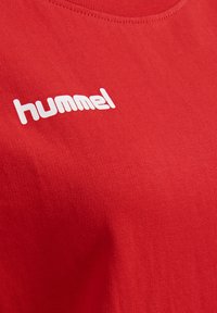 Rode katoenen t-shirt met ronde hals en een witte "hummel" logo dat op de voorkant is gedrukt. De stof heeft een gladde textuur.