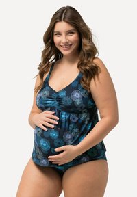 Tankini de maternité en bleu foncé avec des motifs floraux turquoise, bretelles réglables et un design froncé pour un confort et un soutien accrus.