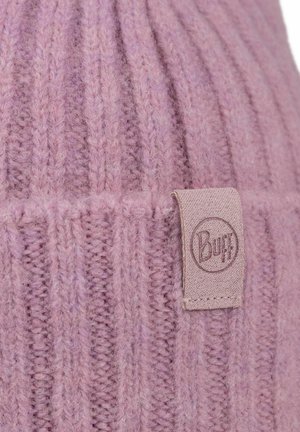 Knitted beanie in soft light pink wool with vertical ribbing. Features a tan fabric tag with embossed logo. Cozy texture and warm design.
