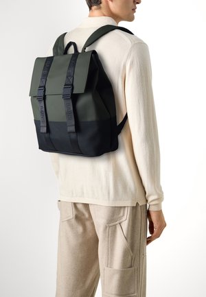 Zaino in materiali verde oliva e nero; forma rettangolare con spallacci regolabili e un pannello pieghevole fissato da due fibbie.