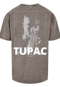 Gray oversized t-shirt with a faded graphic print of a person with hands together. Front text reads "TUPAC" and "TUPAC SHAKUR."