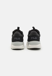 Black athletic shoes with a soft textile upper and grey accents. Back features Fila logo, pull tab, and a thick, cushioned white sole.