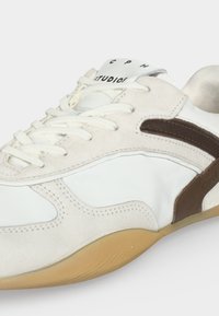 Άσπρο και μπεζ χαμηλό παπούτσι με καφέ ρίγα, κορδόνια και σόλα από καουτσούκ.