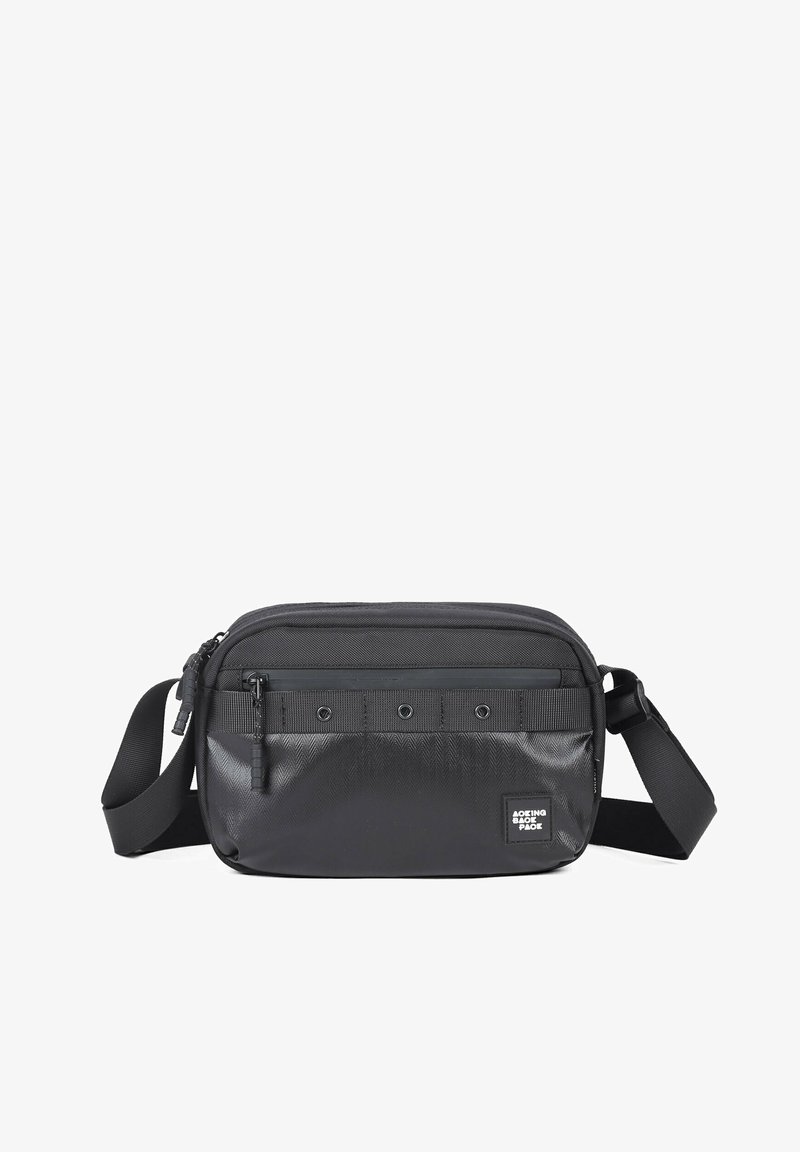 Petit sac bandoulière noir avec sangle réglable, poche avant zippée, détails œillets et panneau inférieur texturé.