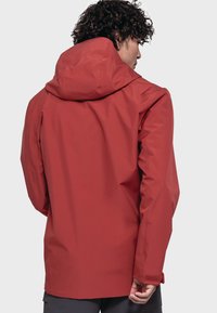Rote wasserdichte Jacke mit Kapuze, entworfen mit einer glatten Textur, verstellbaren Ärmelbündchen und einem lockeren Schnitt für Komfort.