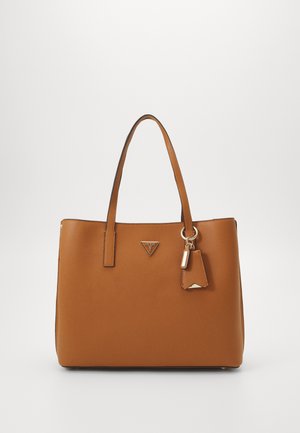 Hellbraune Leder-Tote-Tasche mit zwei Griffen, dreieckigem Markenlogo und angebrachtem Schlüsselanhänger mit Anhänger auf weißem einfarbigem Hintergrund.