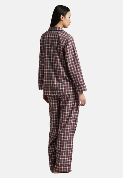 Červený a zelený kostkovaný pyžamový set s dlouhými rukávy a volnými kalhotami. Vyrobený z měkké látky, s uvolněným límcem a zapínáním na knoflíky.