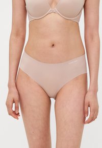 Bézs színű pamut keverék hipster bugyi sima felülettel és magas derékkal. Diszkrét Calvin Klein logo a derékpánton.