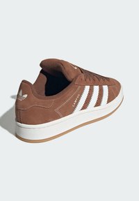 Brown suede sneaker with white three-stripe design, rubber sole, and padded collar. Features "CAMPUS" branding on the side.