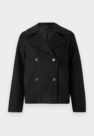 Svart todelt jakke med skrå krage, laget av et teksturert stoff. Har fremtredende svarte knapper og en cropped silhuett.