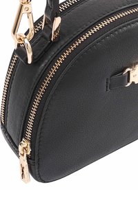 Zwarte leren handtas met textuur, hoek met goudkleurige ritsdetail en een afneembare schouderband.