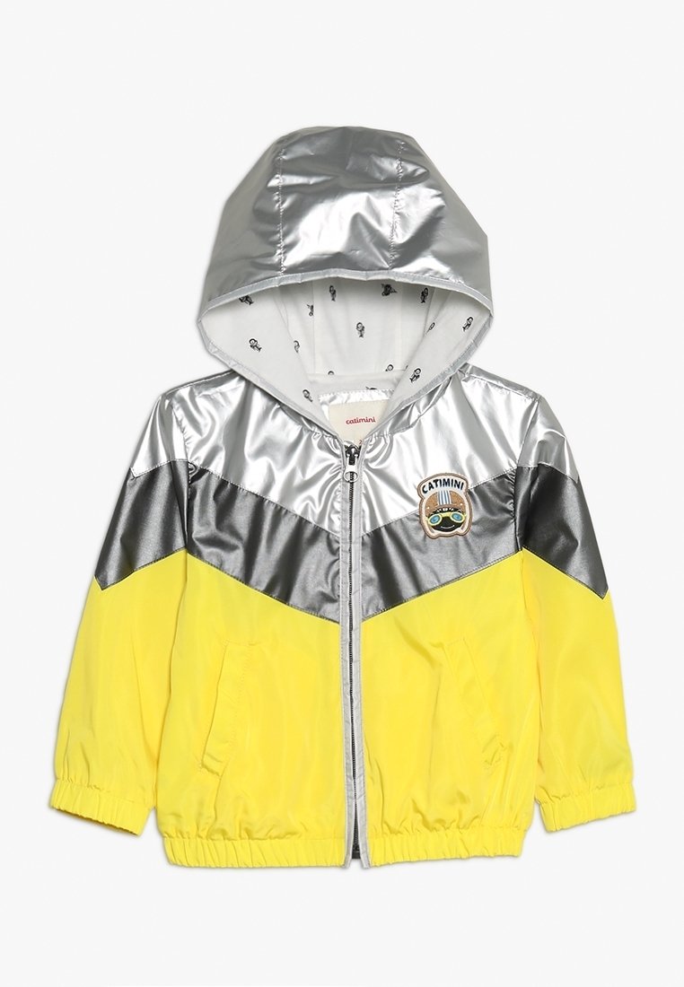 Veste à capuche pour enfants avec des blocs de couleur argent, gris et jaune, fermeture éclair sur le devant, poches latérales et un écusson logo Catimini sur la poitrine.
