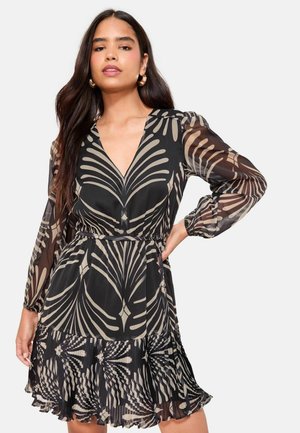 Langärmliges schwarzes Kleid mit tiefem V-Ausschnitt und beigem Blattmuster. Fließendes Chiffonmaterial mit gerafftem Saum und Taillengürtel.