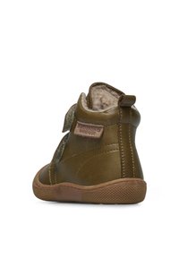 Zelená kožená kotníková bota s suchým zipem, měkkou podšívkou, hnědou gumovou podrážkou a texturovanými detaily na boku a vzadu.