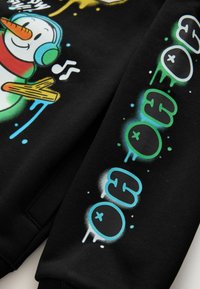Schwarzer Sweatshirt mit einem bunten Grafikdesign eines Schneemanns mit Kopfhörern, musikalischen Noten und Textelementen in Grün und Blau.
