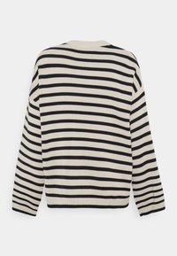 Pull-over rayé beige et bleu marine. Présente un col rond, des manches longues et des poignets et un ourlet côtelés. Texture en tricot douce.