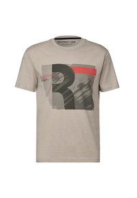 Beige bomull t-shirt med grafiskt tryck i mörkgrön och röd, med texturerade mönster och rund halsringning. Varumärkesetikett synlig.