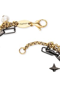 Bracciale a catena oro e nero con accento di perla, chiusura a clip e targhetta incisa. Il design include link texture e dettaglio a forma di stella.