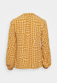 Blusa a maniche lunghe gialla senape con motivo a scacchi, collo arricciato e maniche con polsini, realizzata in tessuto leggero.