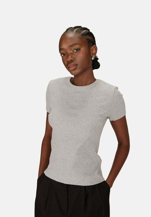 T-shirt gris à manches courtes ajusté en tissu côtelé, avec un col rond et un subtil détail brodé sur la poitrine.