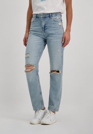 Lichtblauwe versleten jeans met gescheurde knieën, rechte pasvorm, hoge taille en rafelige zomen, gecombineerd met witte sneakers.