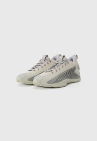 Scarpe sportive grigio chiaro realizzate in materiali a rete e gomma, con un design snello, pannelli laterali testurizzati e chiusura con lacci.
