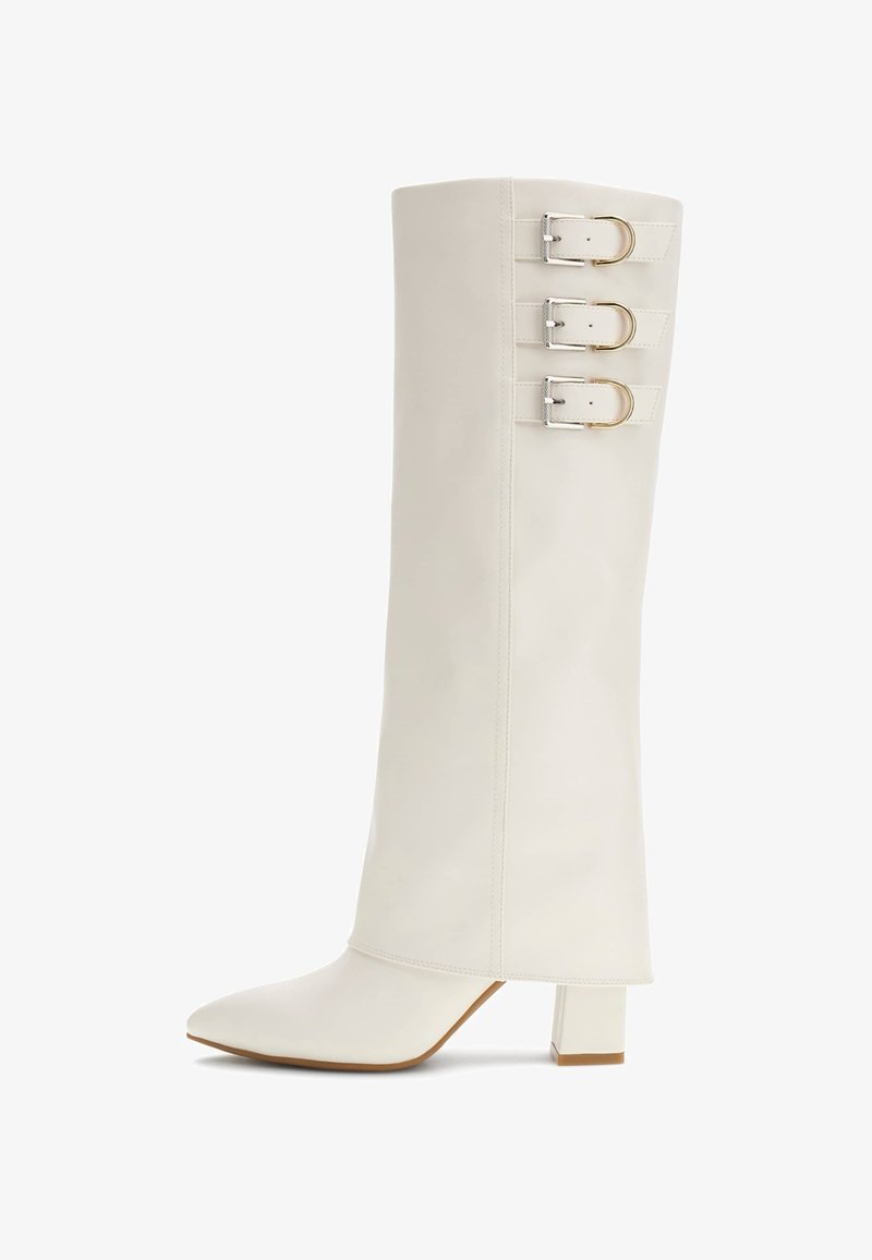 Térd fölé érő, fehér bőrcipő hegyes orral, három fém csattal és négyzet alakú blokk sarkal. Simább textúra, minimalista dizájn.