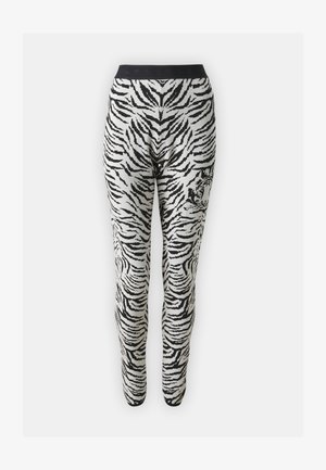 Svart-hvite tigermønstrede leggings med svart linning og elastisk materiale, designet for en tettsittende silhuett.