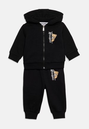 Sort toddler hættetrøje og bukser s frontlynlås med Moschino-logo og en bamse-grafik på både trøje og bukser.