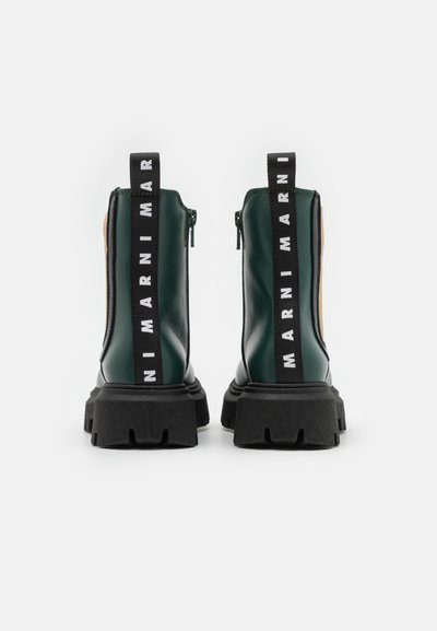 Botas de tornozelo verdes de couro com sola de borracha preta, fecho de zíp e puxador de tecido preto com o logótipo branco da marca ao longo dos lados.