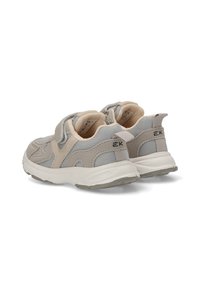 Zapatillas deportivas en beige y gris con materiales de malla y ante, suela acolchada, correa ajustable y detalles texturizados en la parte superior.