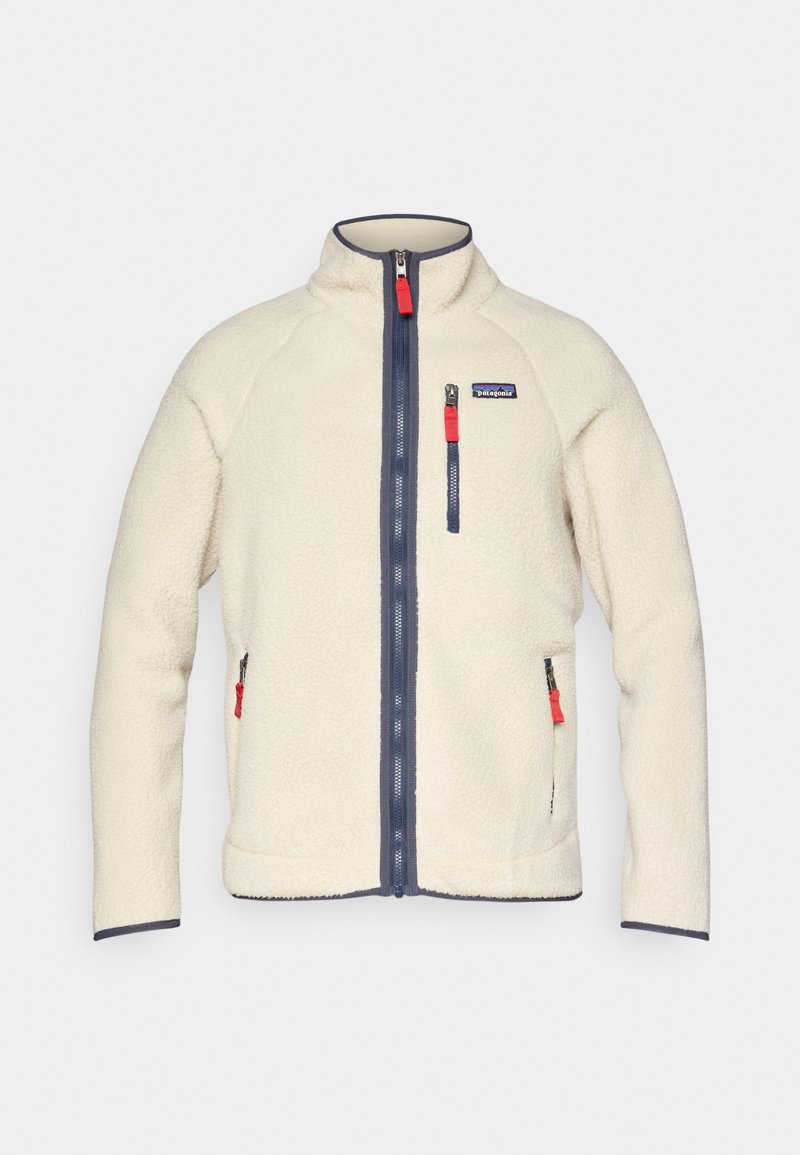 Giacca in pile crema con colletto alto, cerniere blu navy e tiranti delle cerniere rossi a contrasto. Presenta tasche laterali e una tasca sul petto. Superficie testurizzata.