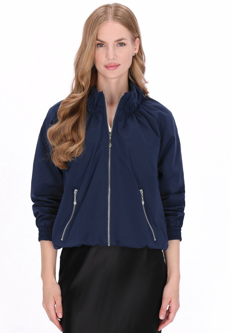 Marineblauw bomberjack met een ritssluiting aan de voorkant, een geplooide halslijn, geribbelde manchetten en twee zijzakken met ritssluiting. Lichtgewicht en met een gladde textuur.