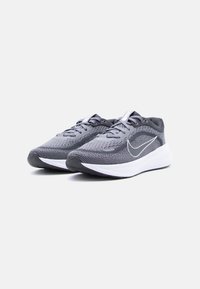 Ζευγάρι γκρι και μαύρα παπούτσια τρεξίματος Nike με λευκές μεσαίες σόλες και κορδόνια, εμφανισμένα σε λευκό φόντο.