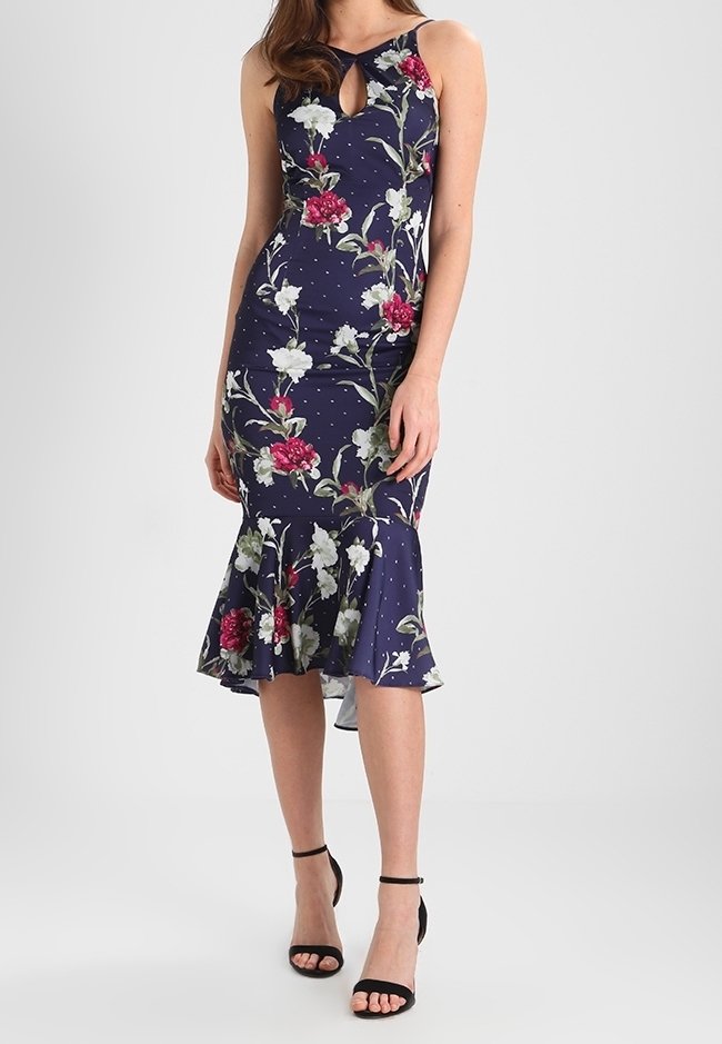 Abito floreale navy con design senza maniche, scollatura a chiave e orlo svasato. Presenta pois bianchi e motivi floreali vivaci in rosso e bianco.