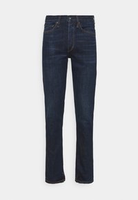 Jeans de mezclilla azul oscuro con diseño de pierna recta, costuras visibles y cinco bolsillos. La tela tiene una textura suave y un ligero desvanecimiento.