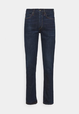 Jeans de mezclilla azul oscuro con diseño de pierna recta, costuras visibles y cinco bolsillos. La tela tiene una textura suave y un ligero desvanecimiento.