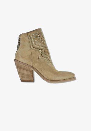 Stivaletto alla caviglia in camoscio color tabacco con tacco a blocchi impilati, borchie decorative a motivo geometrico e chiusura con cerniera sul retro.