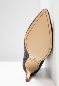 Gray felt stiletto heel with a pointed toe, featuring red and white stripes. The sole is smooth beige leather with minimal detailing.