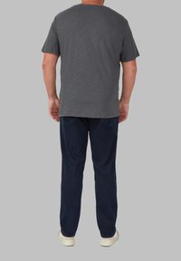 Szary t-shirt z krótkim rękawem i ciemnoniebieskie spodnie. T-shirt ma okrągły dekolt i luźny krój. Spodnie mają prostą nogawkę z klasycznym wzorem kieszeni.