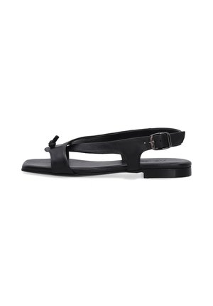 Sort flad sandal med åben tå, knudedetalje på frontstroppen og justerbar ankelrem med spænde på hvid baggrund.