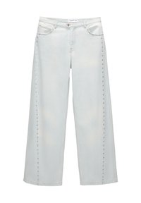 Jean large en denim bleu clair à taille haute, avec des clous métalliques le long des côtés et un design classique à cinq poches.